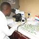 Man looking through microscope for Nigeria NTD mapping