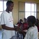 Teacher in Eritrea  giving deworming pill to pupil